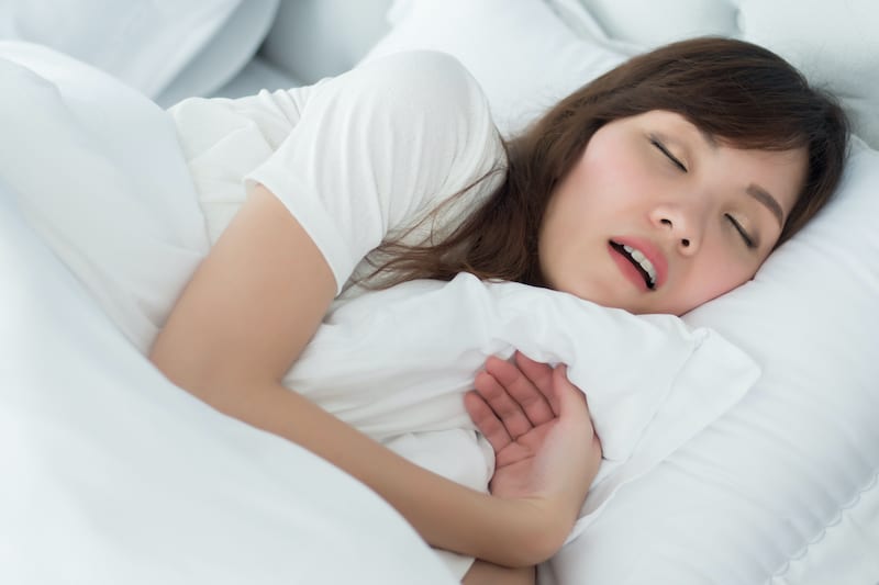 Woman snoring with her mouth open Image