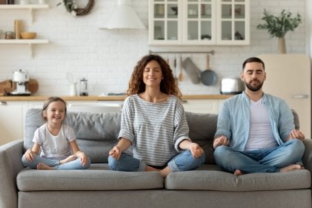 family meditating on a couch