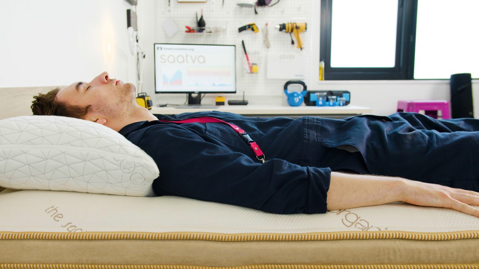 Sleep Foundation tester lying on their back on the Saatva HD mattress