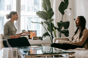 Cognitive Behavioral Therapy for Insomnia (CBT-I) A thoughtful therapy session between a psychologist and a client in a modern office setting.