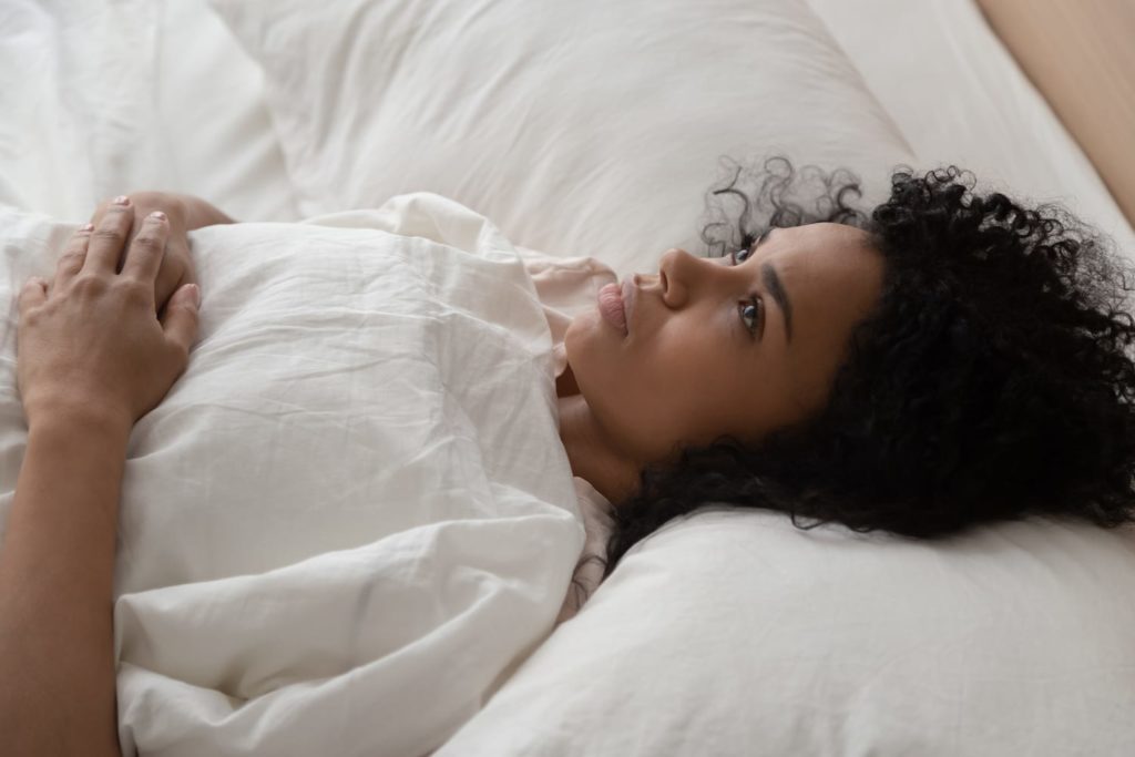 PMS and Insomnia woman lying awake in bed