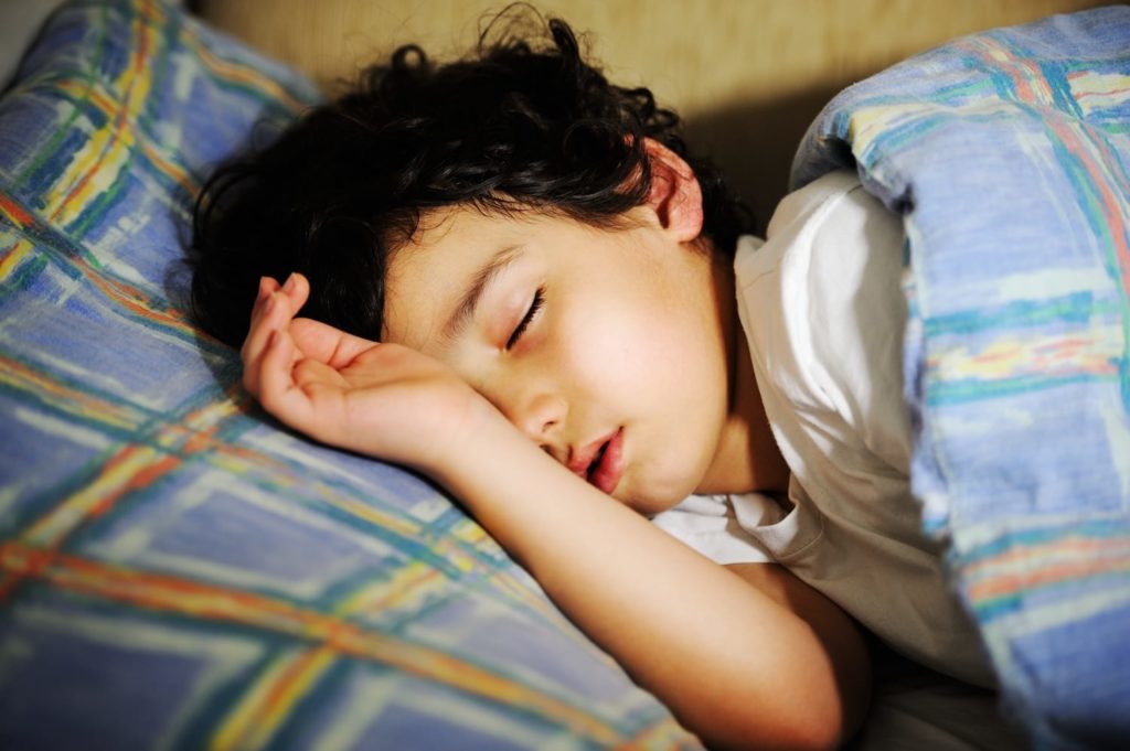 little boy sleeping in bed