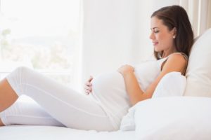 pregnant woman laying in bed