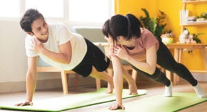 Asian couple doing exercise together at home.