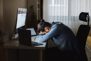 Young man working from home has fallen asleep at their computer.