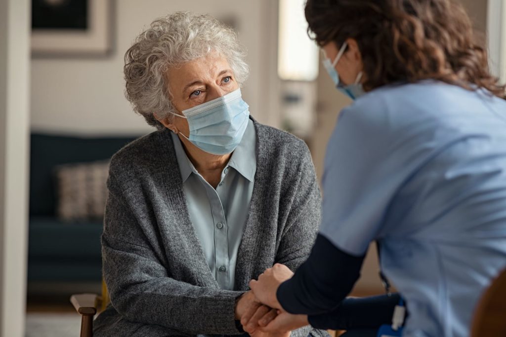 elderly woman talking to caregiver