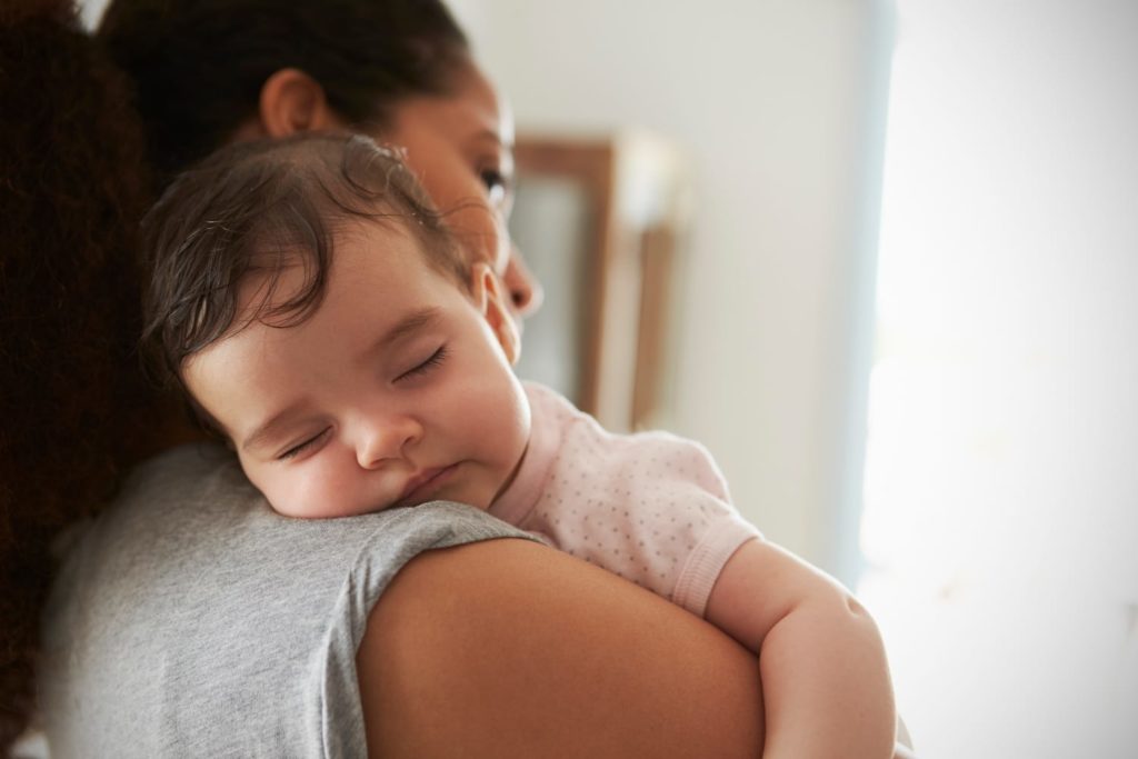 woman holding sleeping baby