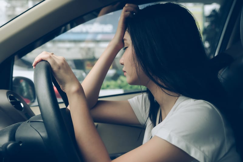 Young sleepy woman in drivers seat