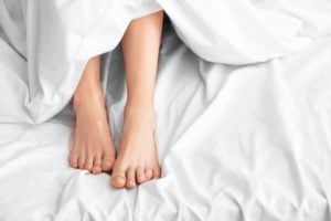 Person's legs showing outside sheets
