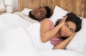 man snoring in sleep, woman annoyed