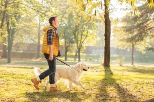 man walking through the park with his dog