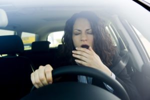 woman yawning while driving car