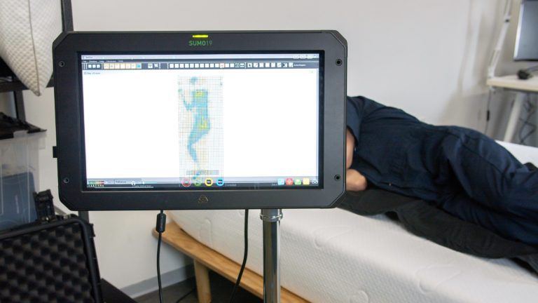 Sleep Foundation tester undergoing side-sleeping pressure mapping on a Puffy mattress