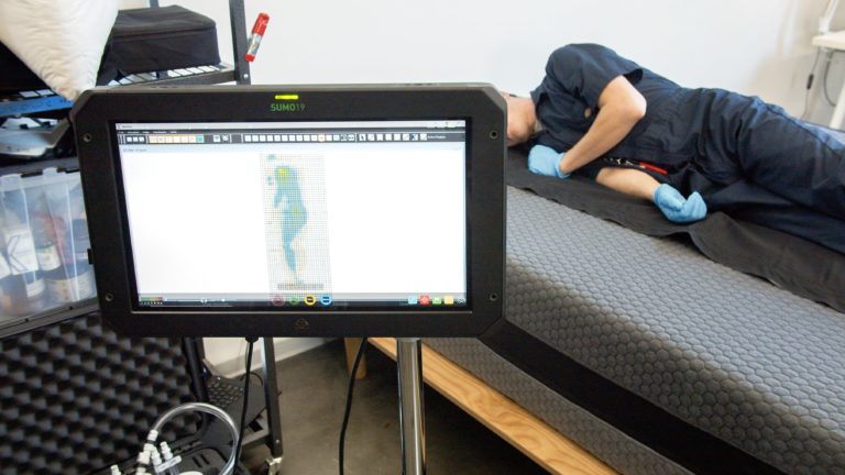Sleep Foundation tester undergoing side-sleeping pressure mapping on the Layla Hybrid mattress