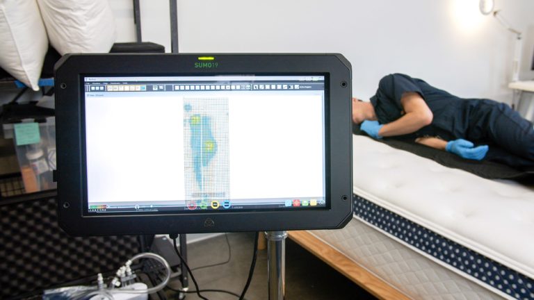 Sleep Foundation tester undergoing side-sleeping pressure mapping on the WinkBed mattress