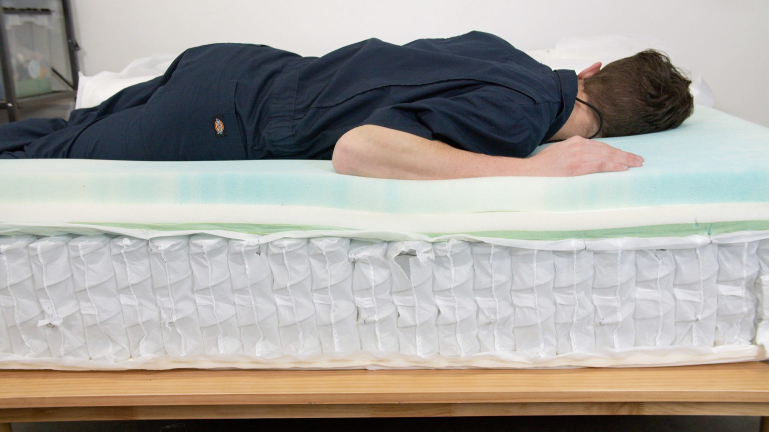 Sleep Foundation tester lying on his stomach on the exposed layers of the Brooklyn Bedding Sedona mattress