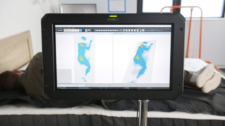 Sleep Foundation tester undergoing side-sleeping pressure mapping on an Allswell mattress