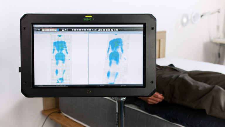 Sleep Foundation tester undergoing back-sleeping pressure mapping on the Allswell Brick mattress