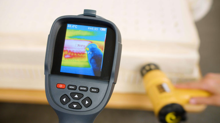 Sleep Foundation testing the Avocado Latex Mattress for heat retention with a thermal camera and heat gun