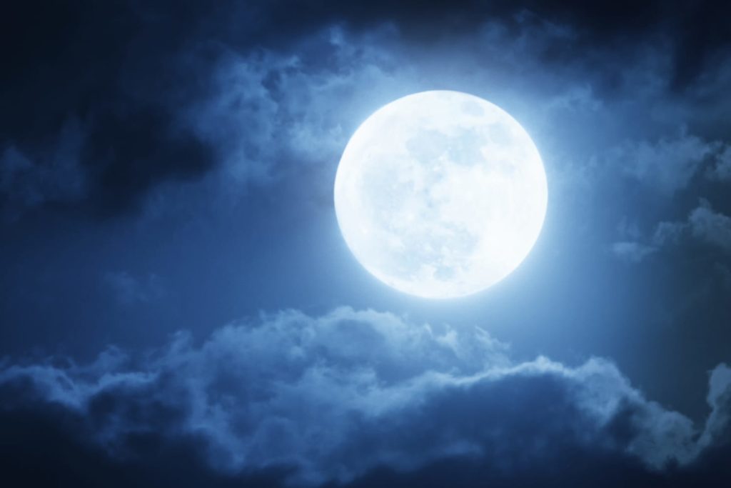 Do Moon Phases Affect Your Sleep? Full moon surrounded by clouds