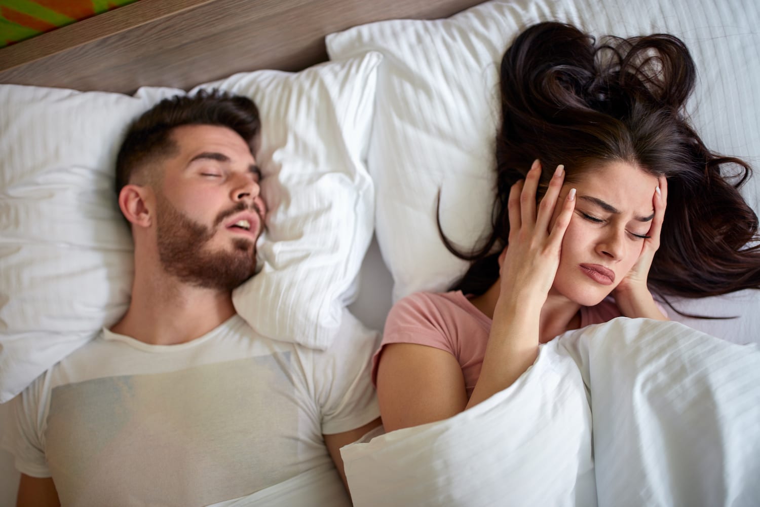 Woman awake in bed because of snoring husband