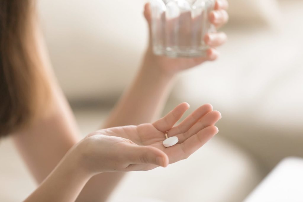 White pill in woman's hand