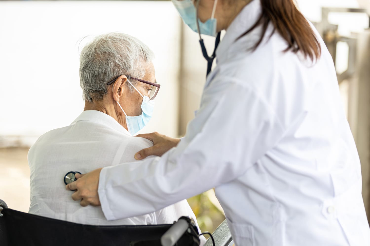 Doctor with a stethoscope on a patient's back, listening for breaths