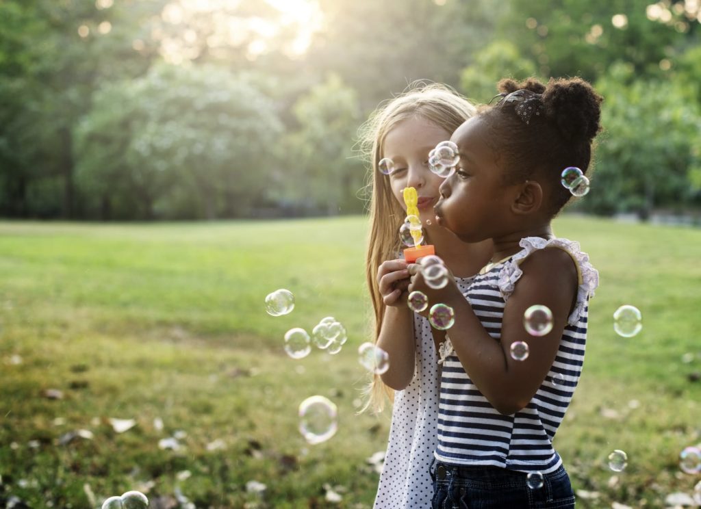 Children playing outside with bubbles