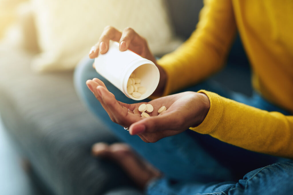 A young woman taking medication at home