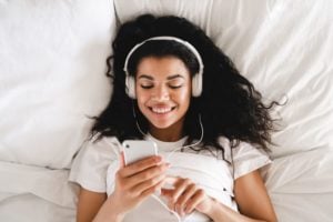 Woman in bed with headphones