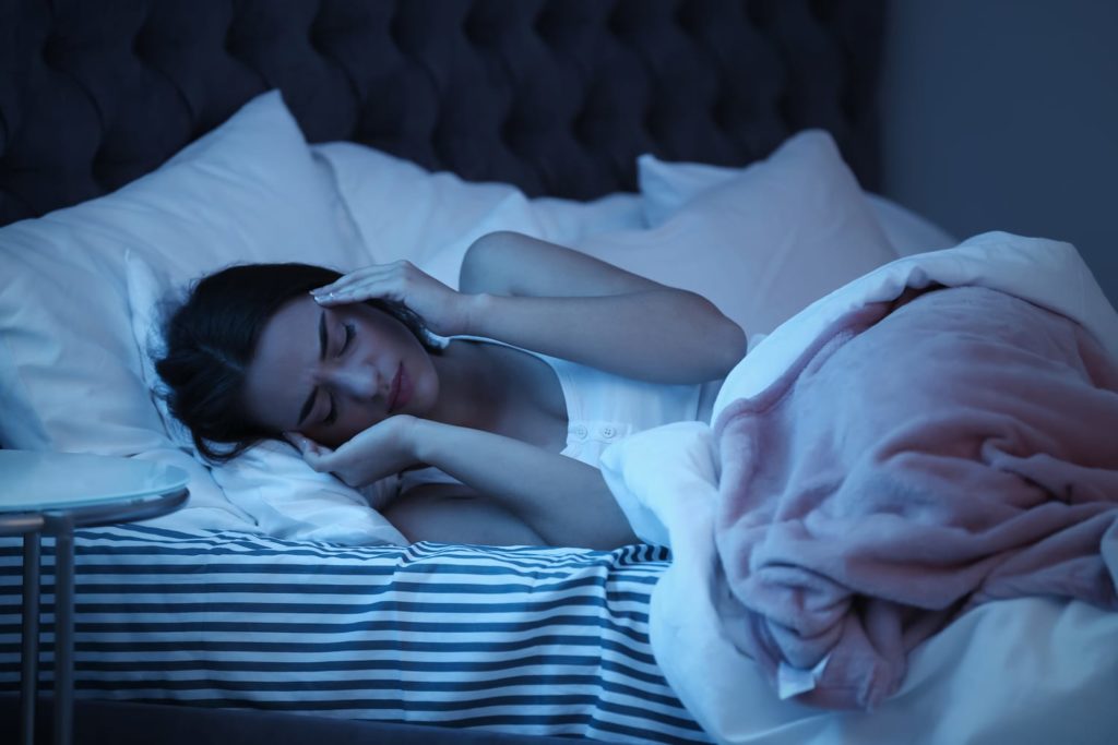 Woman awake with a nighttime headache