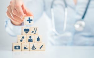 A healthcare professional arranging wood blocks with medical icons