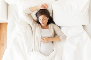 Pregnant woman sleeping in bed