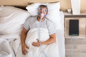 Man in bed using cpap machine