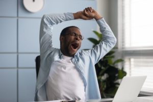 Man yawning at work