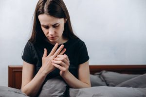Woman holding numb hand in pain