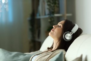Stock photo of woman listening to guided meditation before sleep