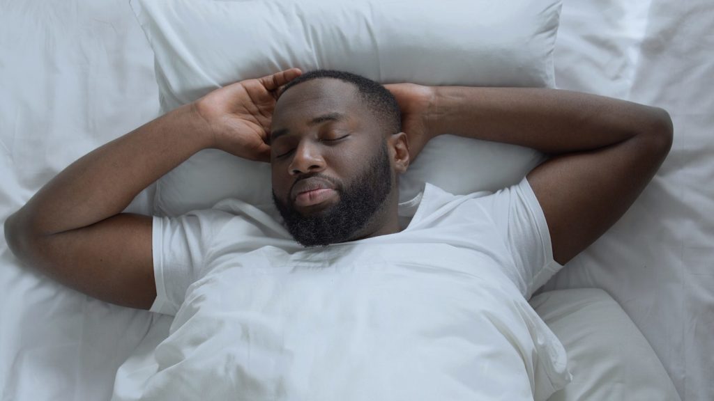 Man in bed sweating while he sleeps