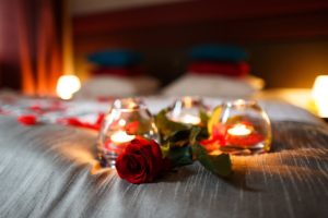 roses and candles on bed