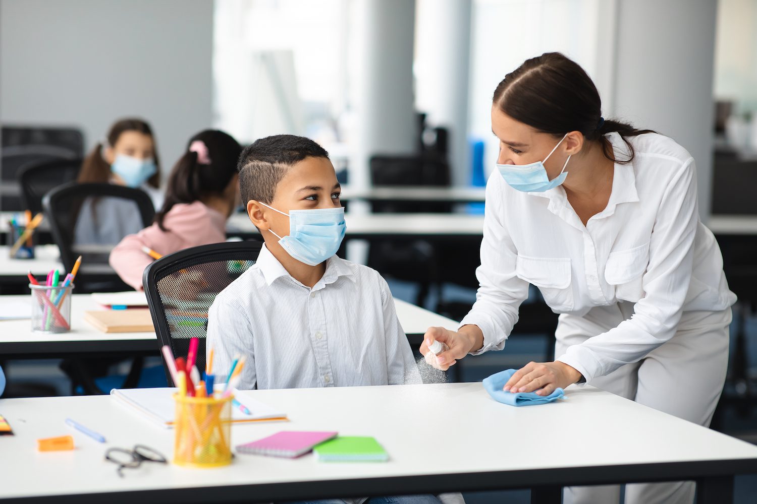 Teacher and student in classroom with masks