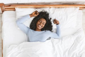 Woman sleeping in starfish position in bed
