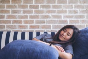 A woman has fallen asleep on a couch