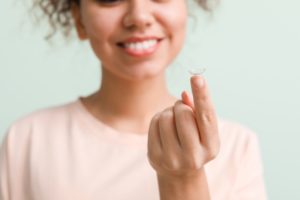 Woman balancing a contact on her fingertip