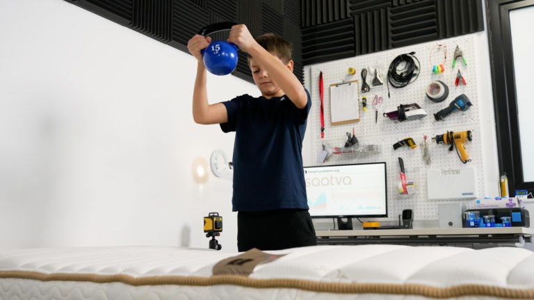 Weight compressing the Saatva Youth mattress during performance testing