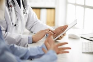 Medical professionals examine a tablet