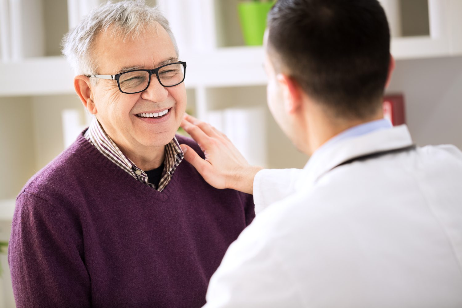 Older man smiles while discussing sleep apnea surgery with a health professional