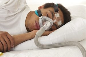 stock photo of a young man wearing a cpap machine