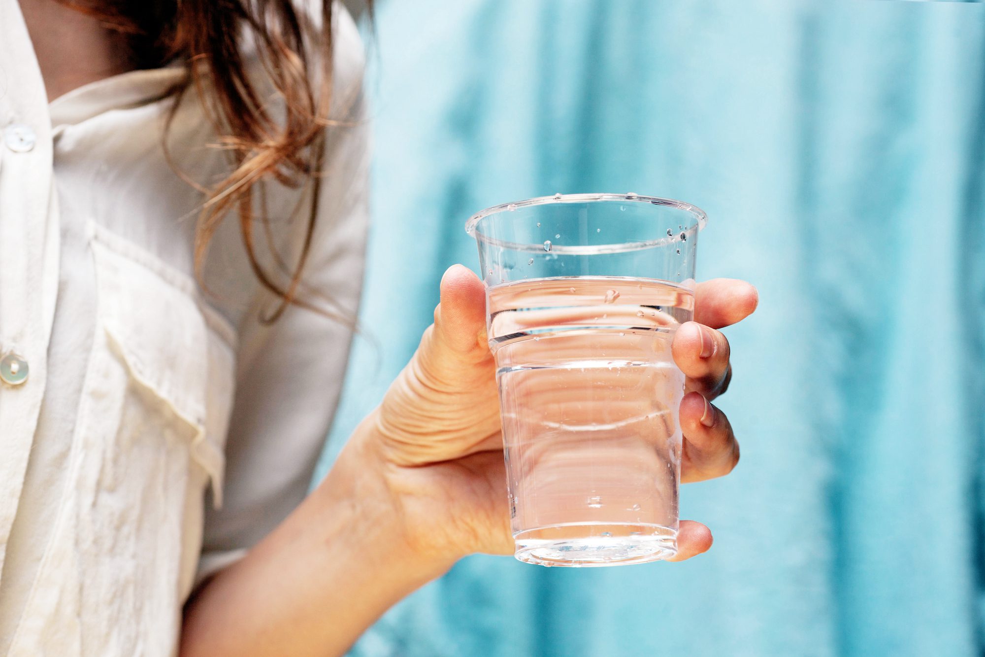 woman holding a glass of distilled water