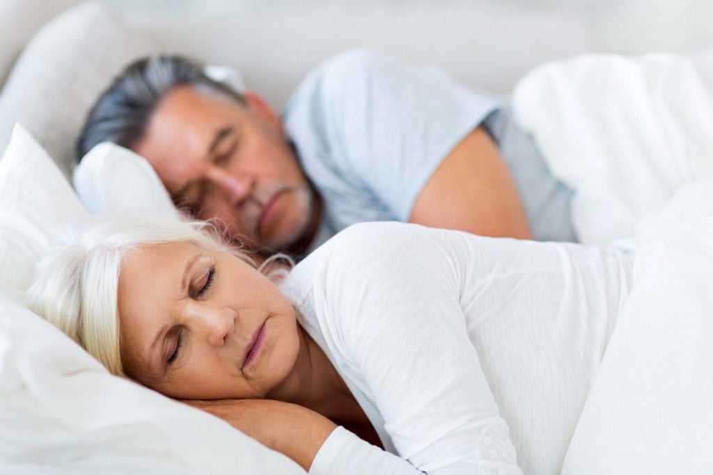 Stock image of older couple sleeping