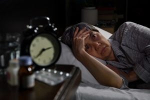 stock photo of an older woman lying awake in bed